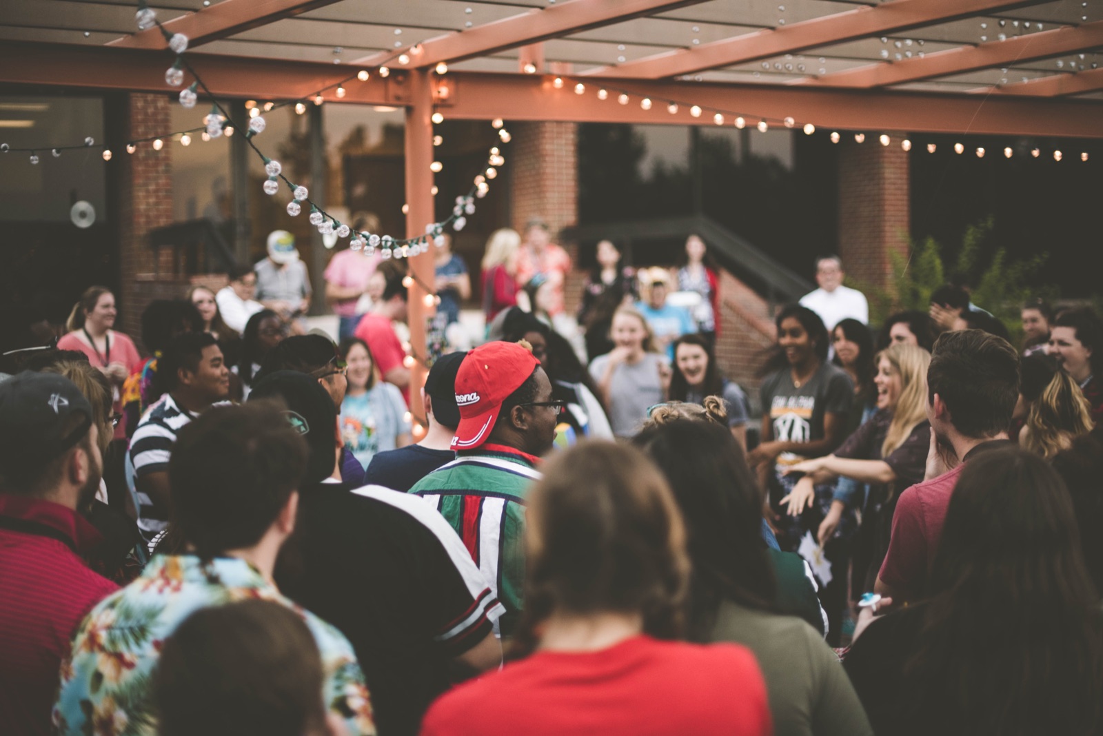 Students gathered at a campus event under string lights