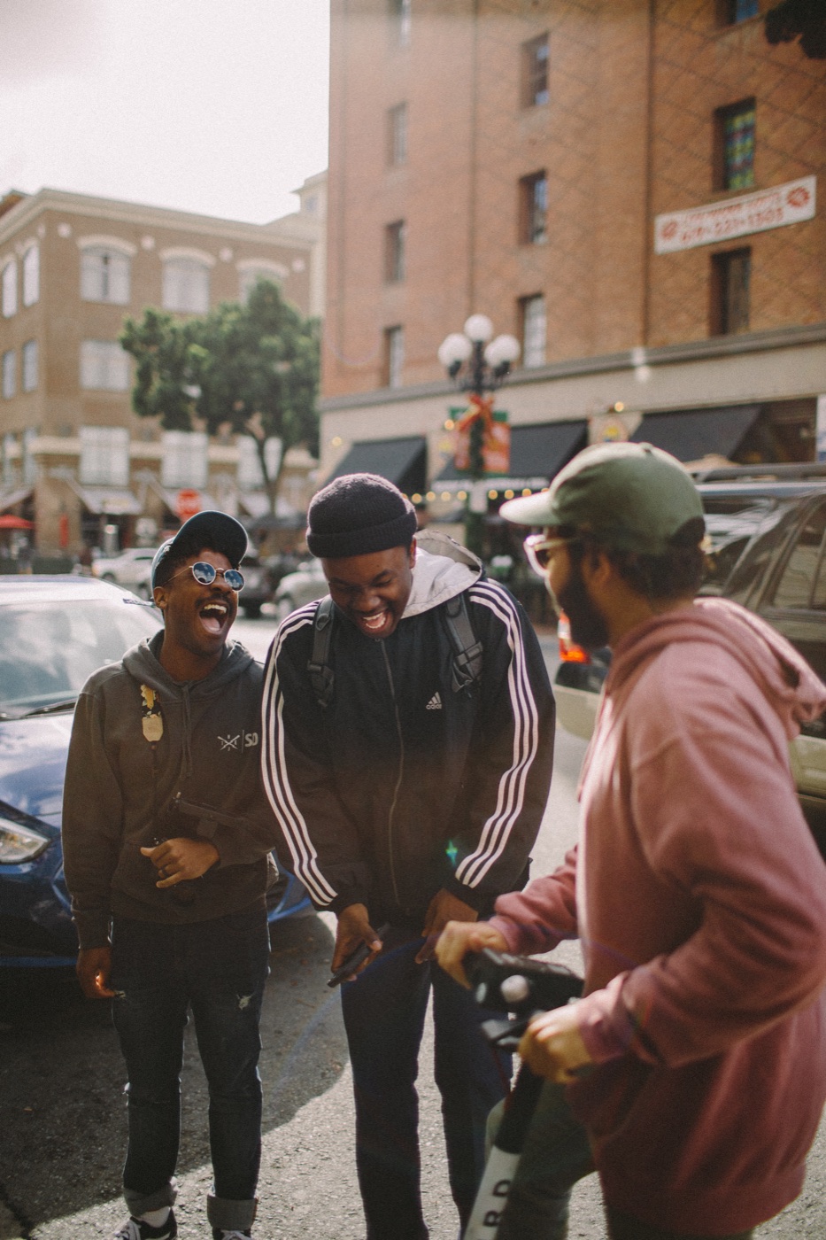 Three college friends laughing together downtown
